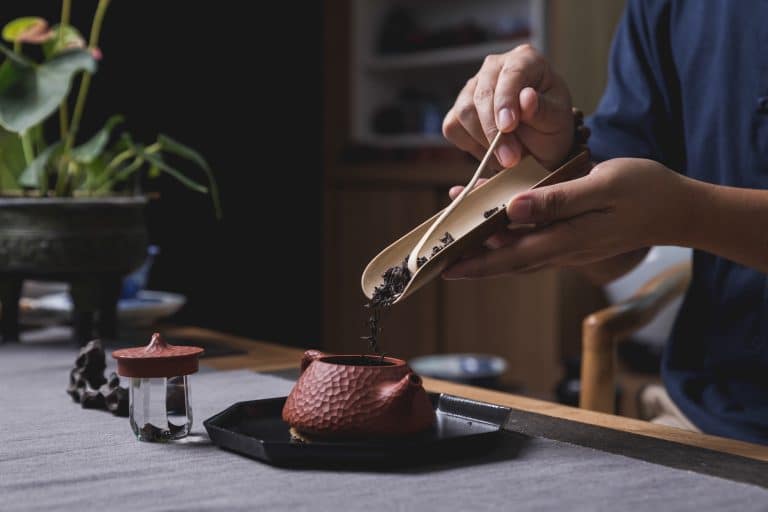 Préparation du thé avec une théière en terre et des tasses de dégustation